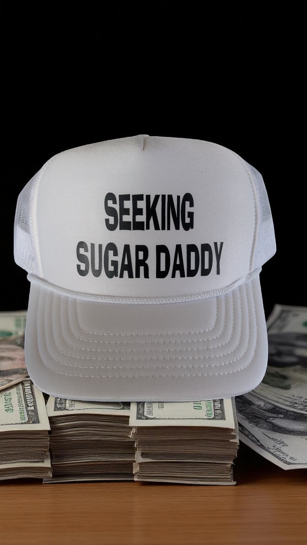 Lakelifewear white foam trucker hat with rope detail and black Seeking Sugar Daddy slogan text on a stack of cash.