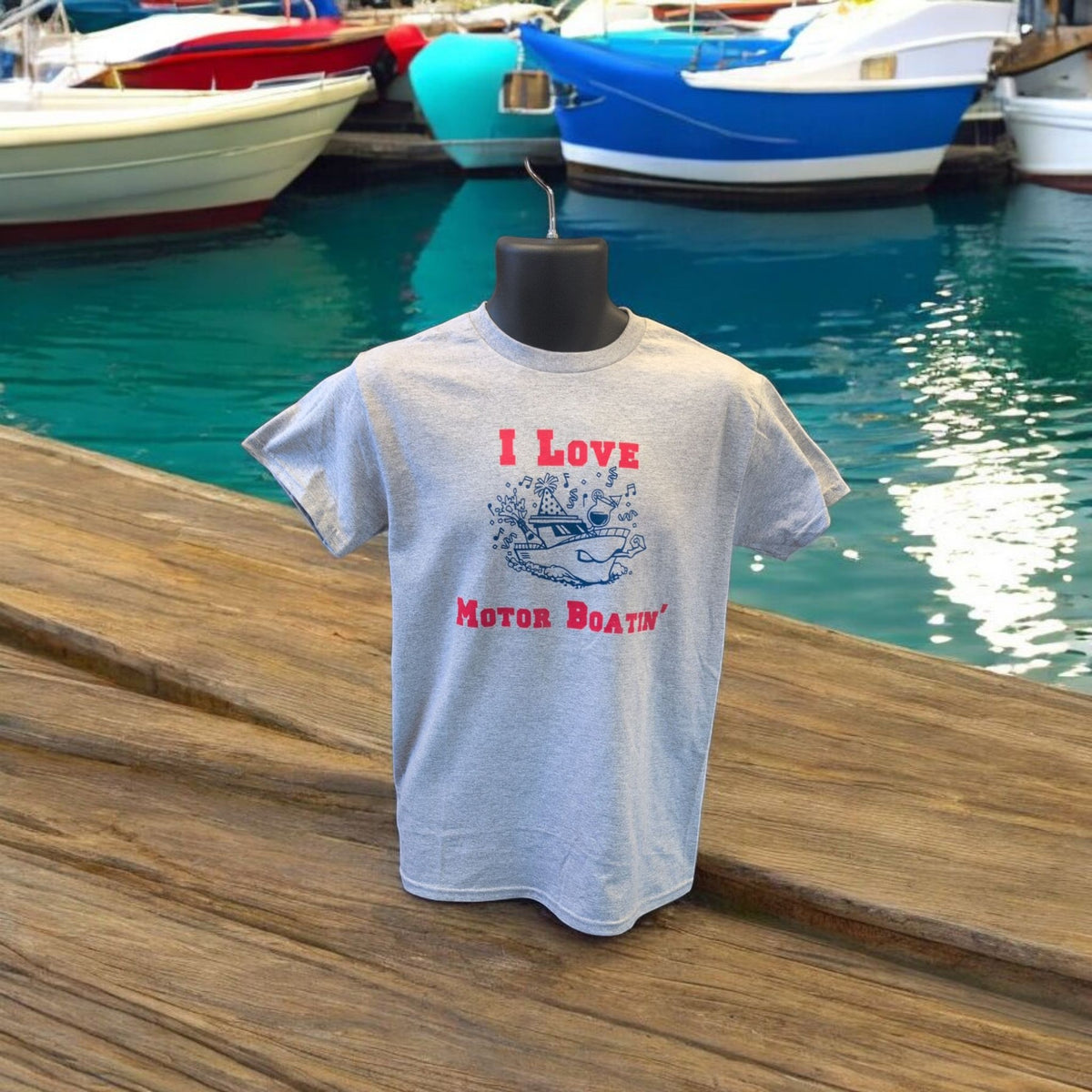 Lakelifewear sport grey short-sleeve t-shirt with I Love Motor Boatin' graphic on a mannequin by a boat dock.
